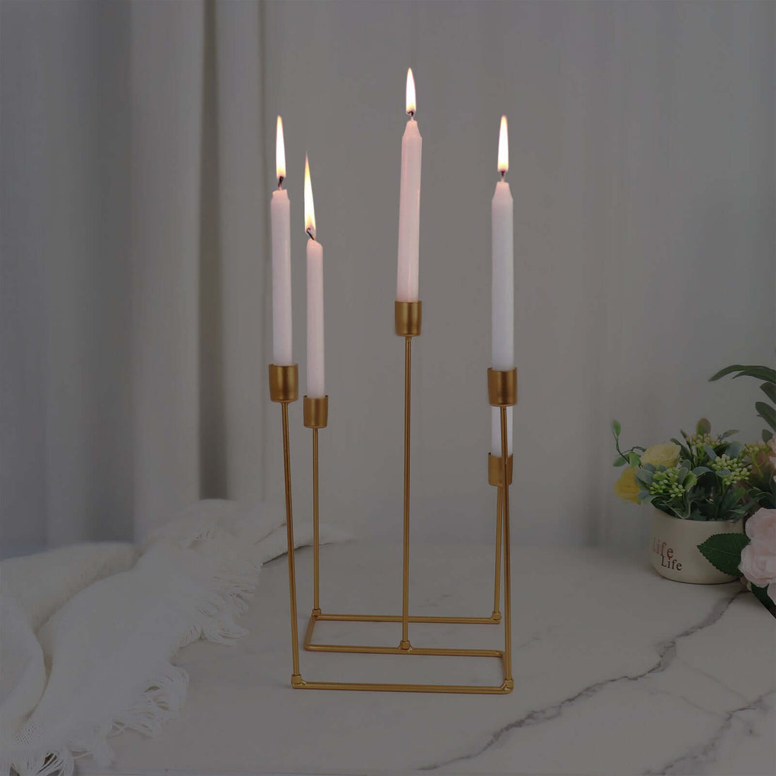 Elegant gold candle holder with five lit candles.