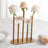 Gold vase with pastel flowers on a table setting.