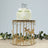 Gold carousel cake stand with horse silhouettes and crystal accents, featuring a cake on top.