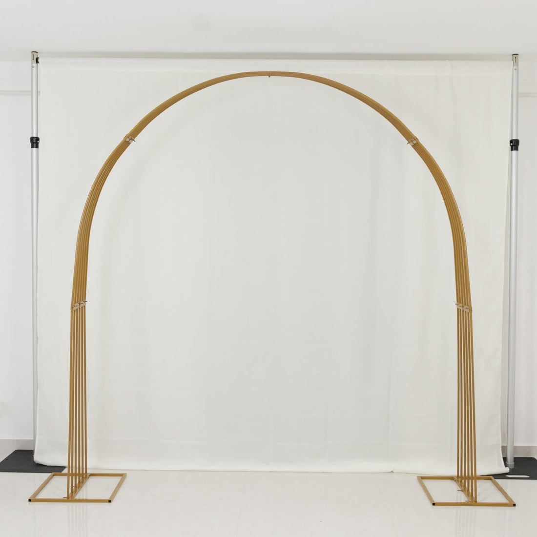 Gold wedding arch on a plain white backdrop