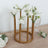 Gold flower vase holder with white roses on a wooden table.