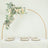 Elegant floral arch decor over a dining table setting with plates and glassware.