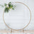 Gold circular floral display stand with greenery and white flowers.