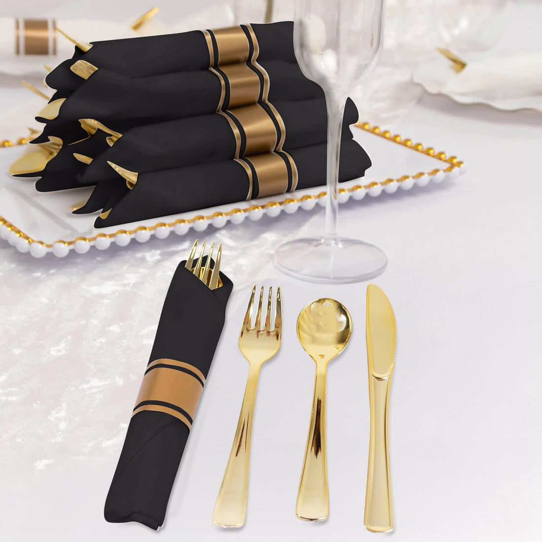 Elegant black napkins with gold stripes, set with gold cutlery and glassware.