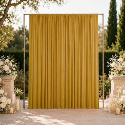 Gold wedding backdrop with floral arrangements and candles outdoors