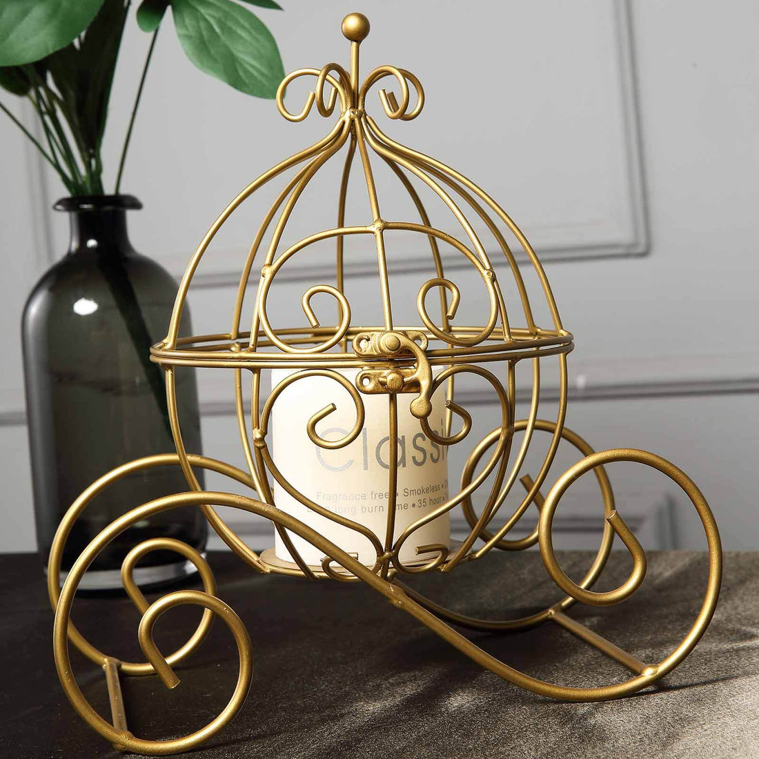 Gold wire decorative candle holder with elegant design, displayed in a styled setting.