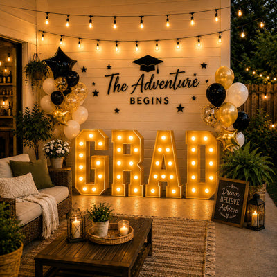 Graduation party backdrop with gold “GRAD” letters and balloons