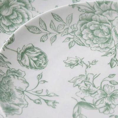 Green floral patterned ceramic plate close-up on white background