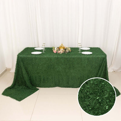 Green grass tablecloth with elegant decor and plates for special occasions.