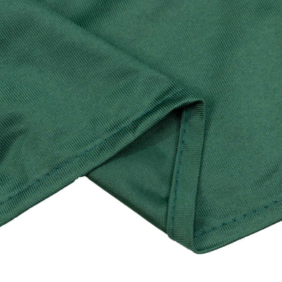 Green knit fabric close-up with stitched hem detail