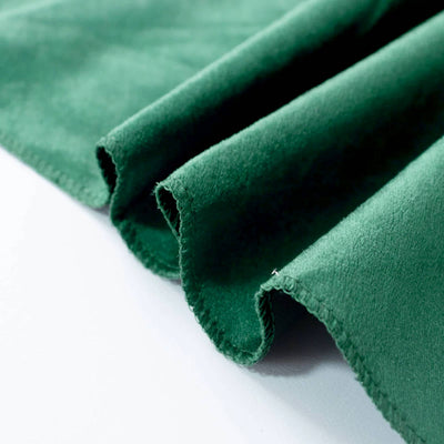 Green suede fabric texture with folded edges close-up