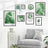 Framed tropical leaf art prints arranged on a wall above a gray sofa with plants.