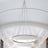 Modern circular chandelier with sleek metallic design hanging in a bright space.