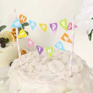 Colorful "Happy Birthday" cake topper with striped straws on a decorated cake.