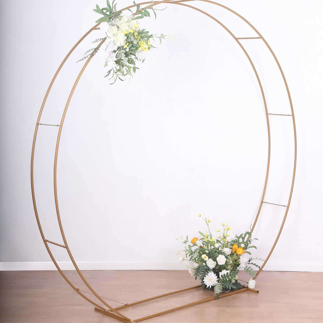 Gold circular flower arch with floral arrangement on a plain background.