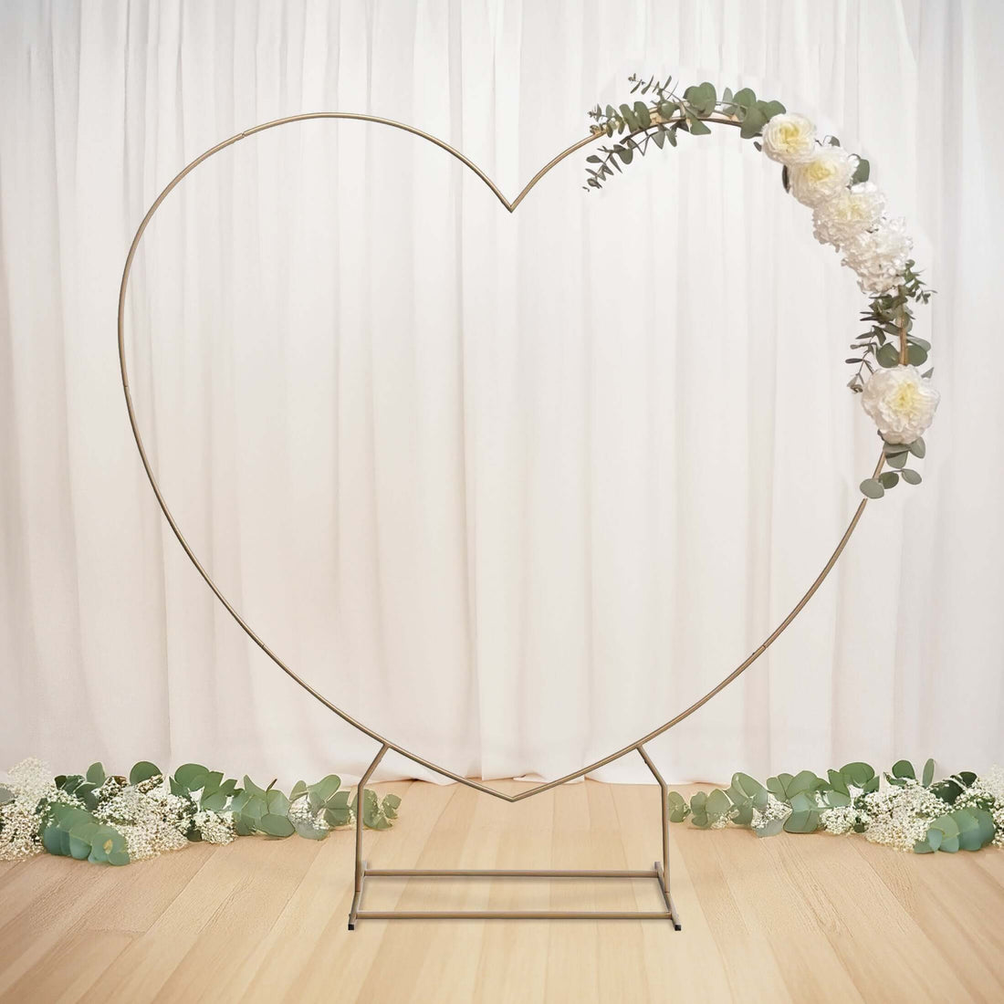 Gold heart-shaped backdrop with floral decoration for events.