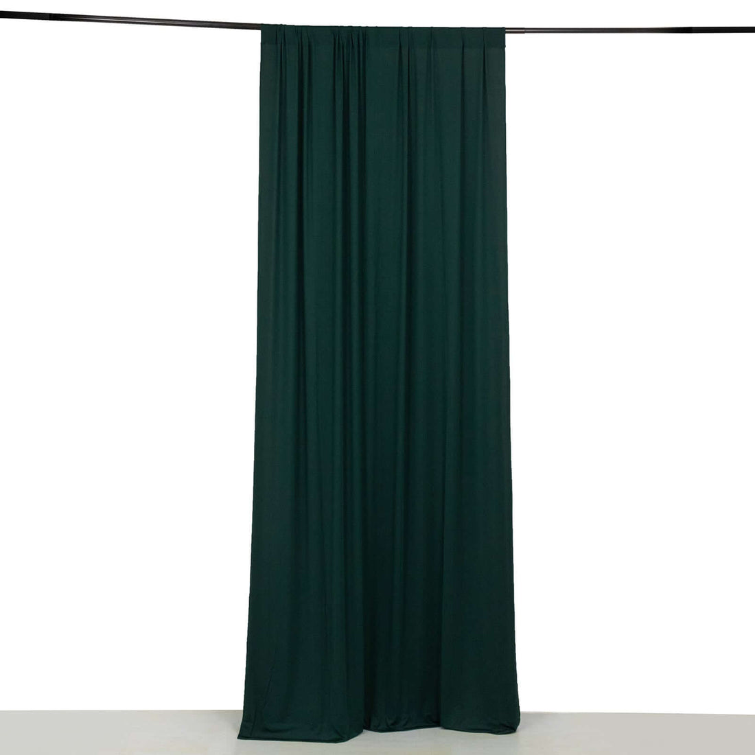 Dark green fabric curtain on a plain backdrop