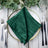 Green satin napkin elegantly placed on a decorative plate. #whtbkgd