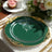 Elegant green plate with gold detailing on a beautifully set table.