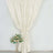 Elegant white curtain draped with floral arrangement in a modern setting.