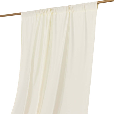 Cream-colored sheer curtain draped on a wooden rod