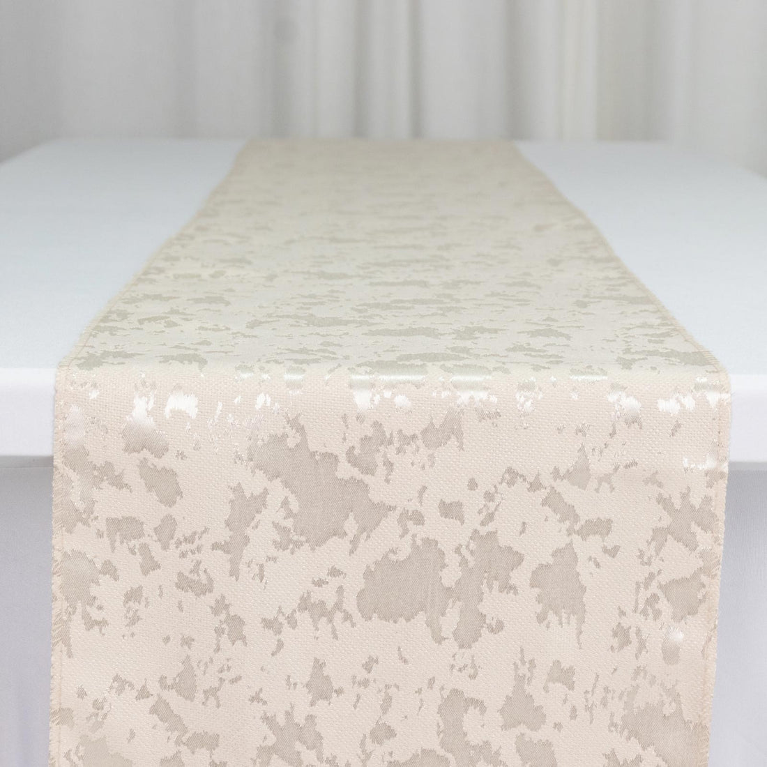 Ivory jacquard table runner on white table, elegant textured fabric close-up