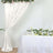 Elegant white drapery and floral arrangement for event decoration.