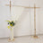 Wedding arch with white drapery and floral arrangement.