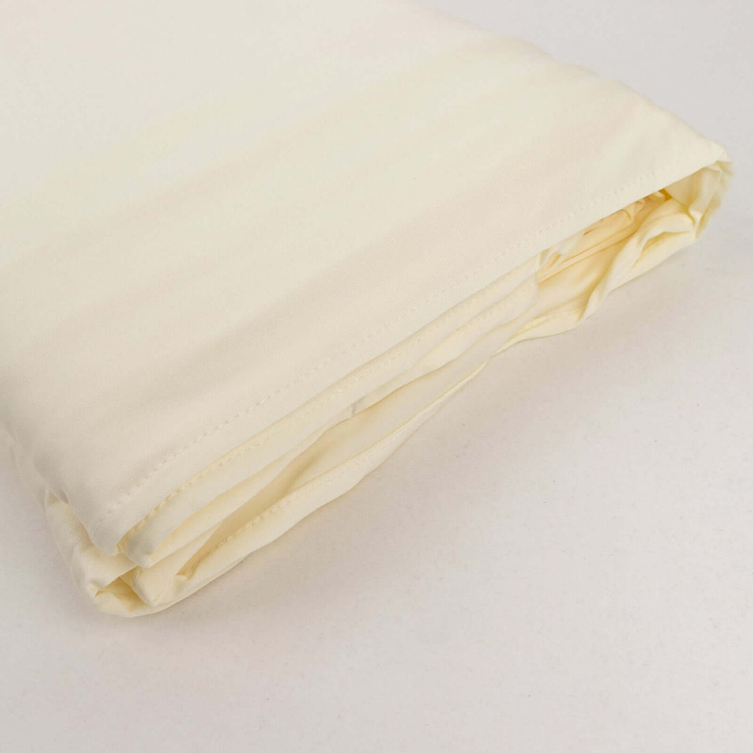 Cream-colored fitted sheet neatly folded