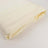 Cream-colored fitted sheet neatly folded