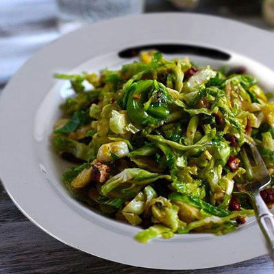 Freshly prepared sautéed greens on a white plate.