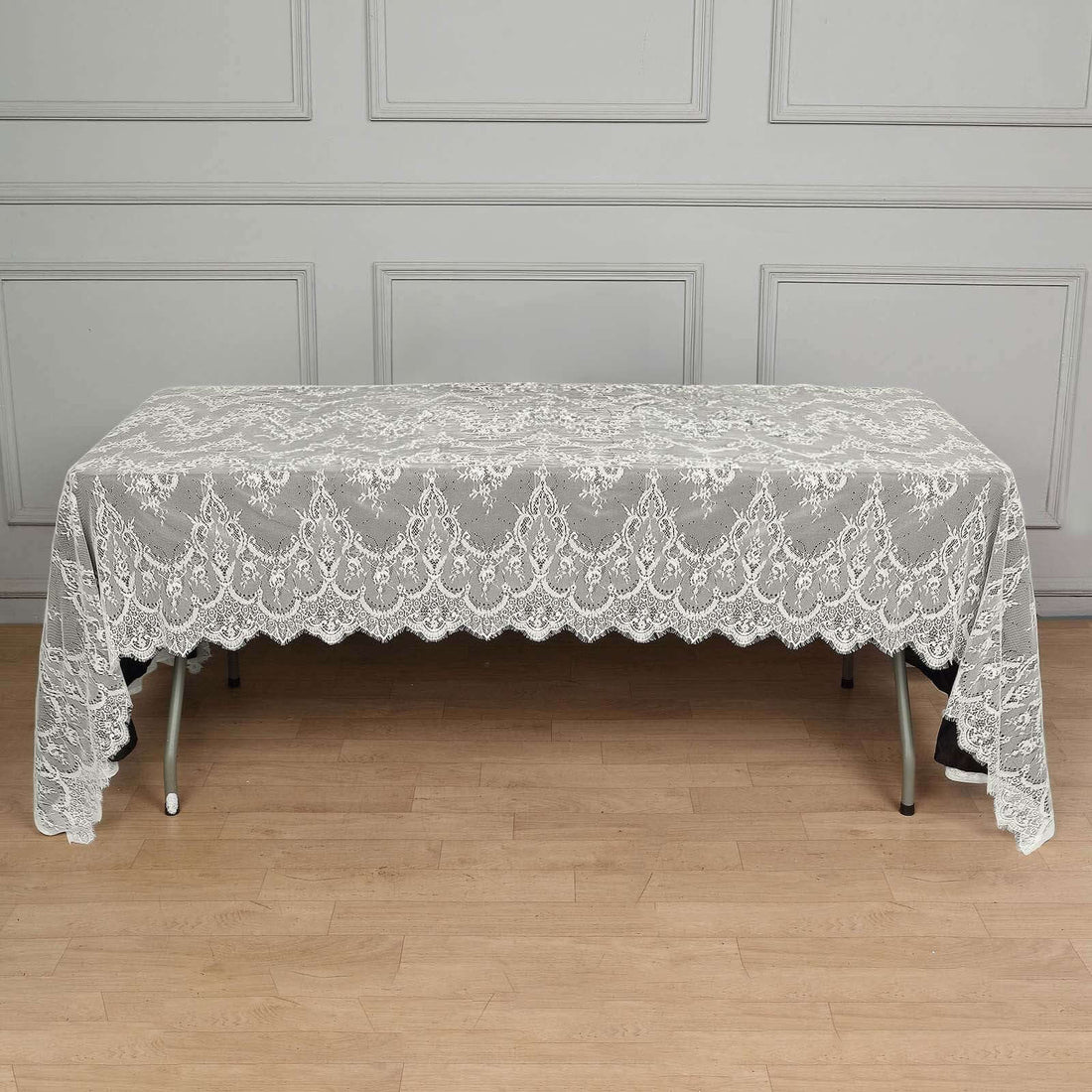 Elegant lace tablecloth draped over a table in a studio setting.