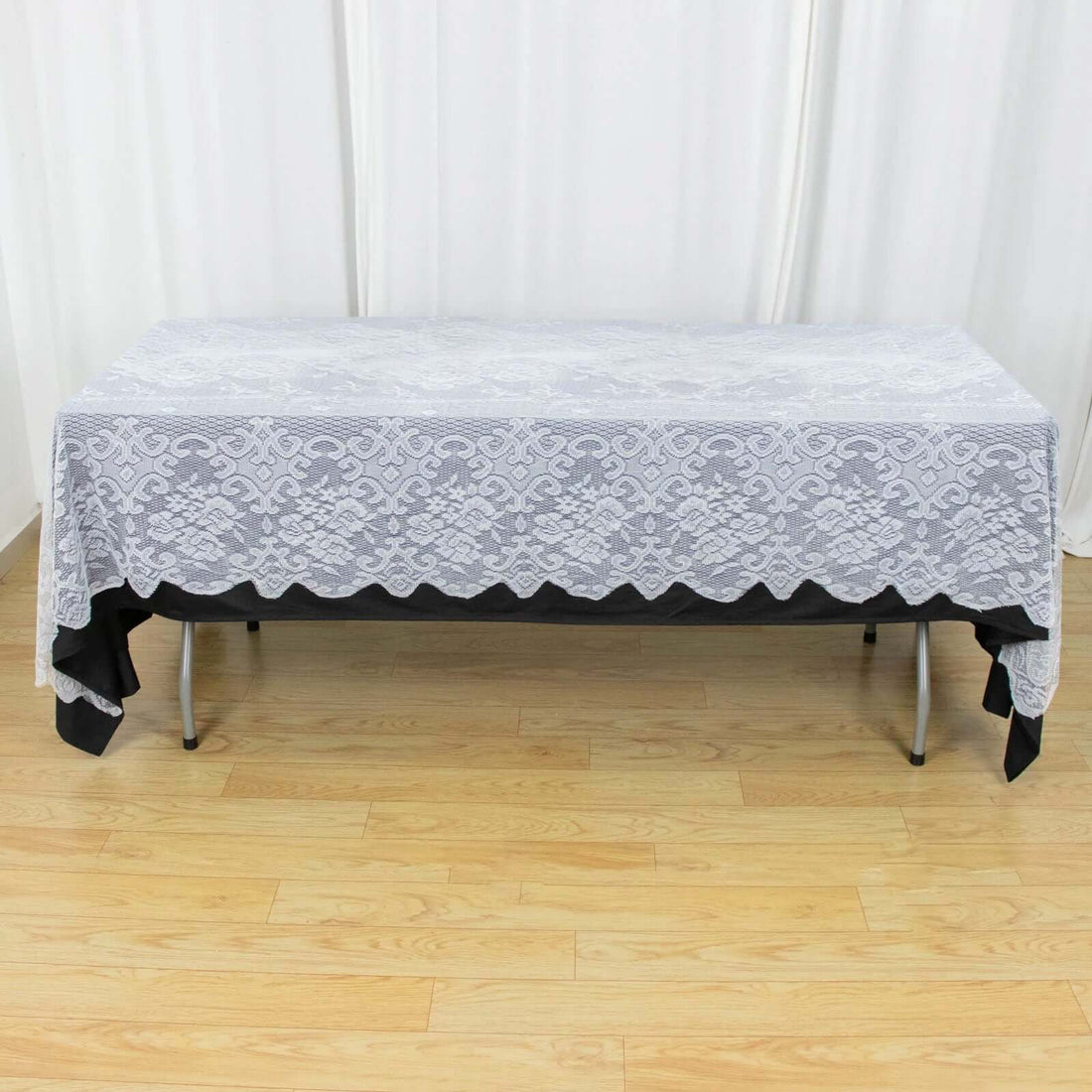 Elegant lace tablecloth draping over a black table.