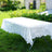 White lace tablecloth on a folding table in a grassy outdoor setting.