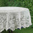 White lace tablecloth with floral design on round table.