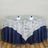 Round lace tablecloth with navy satin underlay and elegant dining setup.