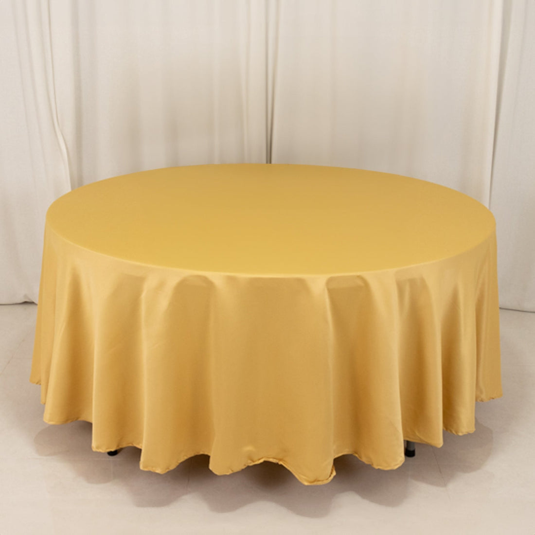 Round yellow tablecloth on a table with elegant draping.