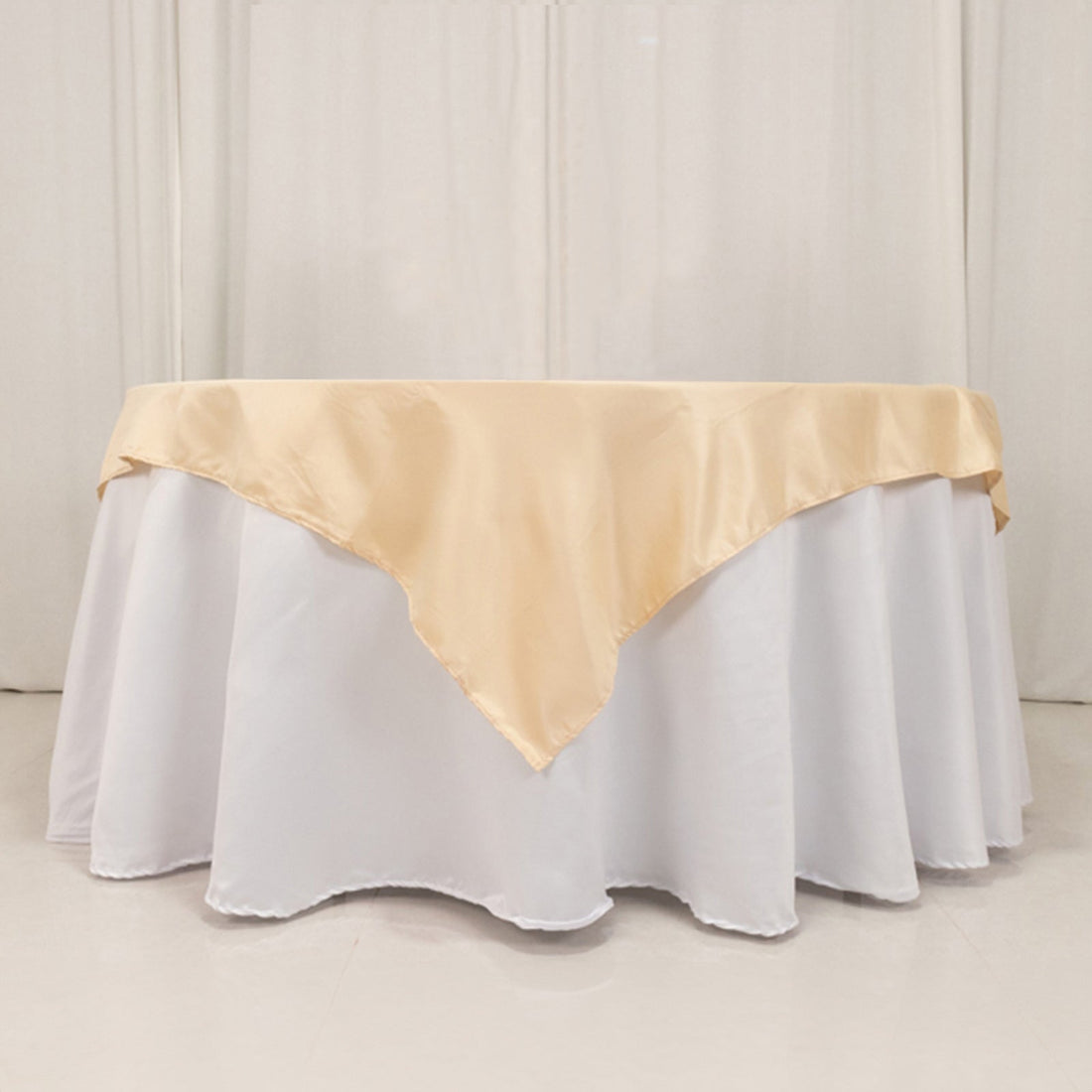 Elegant beige tablecloth draped over a round white table.