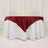 Round table with white tablecloth and burgundy satin overlay