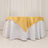 Round table with white tablecloth and gold satin overlay.