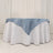 Round table with white tablecloth and blue satin overlay