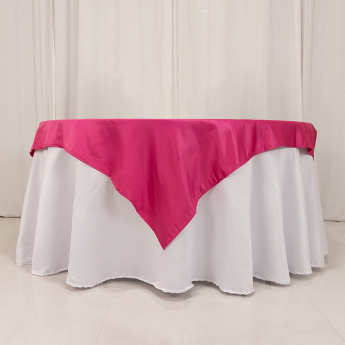 Pink tablecloth draped elegantly over a round white table.