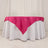 Pink tablecloth draped elegantly over a round white table.