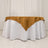 Round table covered with a white tablecloth and a brown satin overlay.