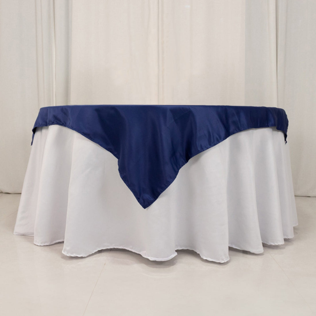 Navy blue tablecloth draped over a round white table