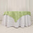 Green satin tablecloth draped over a white table.