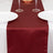 Burgundy table runner on a white table setting with plates and glasses.