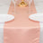 Peach satin table runner on a dining table with gold accents and white plates.
