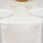 Elegant ivory table runner on a dining table with white plates and glasses.