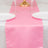 Pink table runner on a white table, set for dining with plates and glasses.